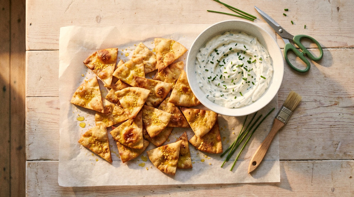 Golden baked pita chips seasoned with Chooki's Vinegar Chicken Salt beside a bowl of creamy chive and onion dip