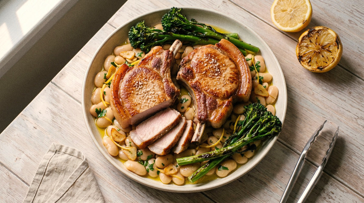 Seared pork cutlets seasoned with Chooki's Zest Chicken Salt on lemony butter beans with charred broccolini