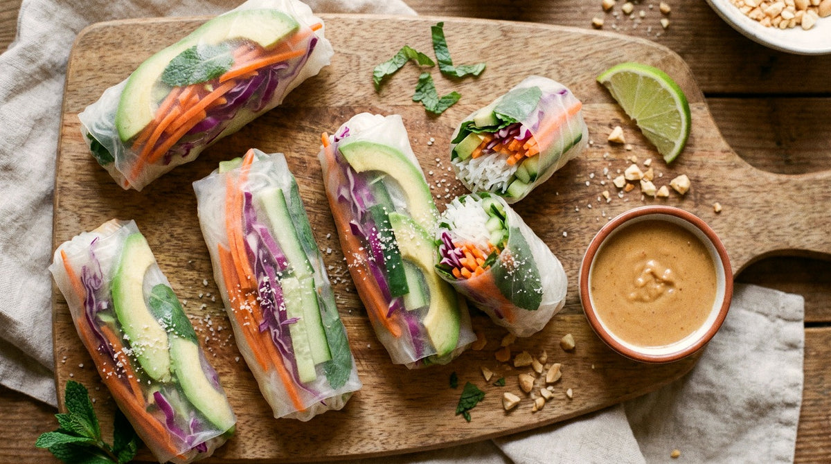 Rainbow rice paper rolls with avocado, carrot and mint seasoned with Chooki's Zest Chicken Salt and a peanut lime dip on a wooden board