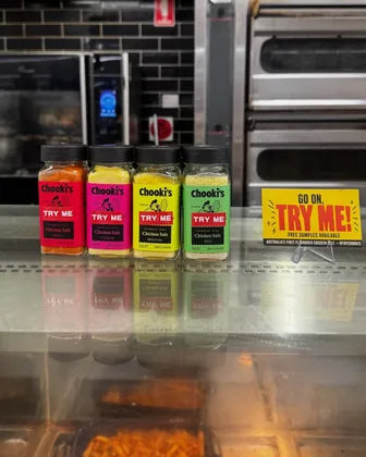 Four Chooki's chicken salt jars with Try Me stickers on the deli counter at Ashcroft's IGA